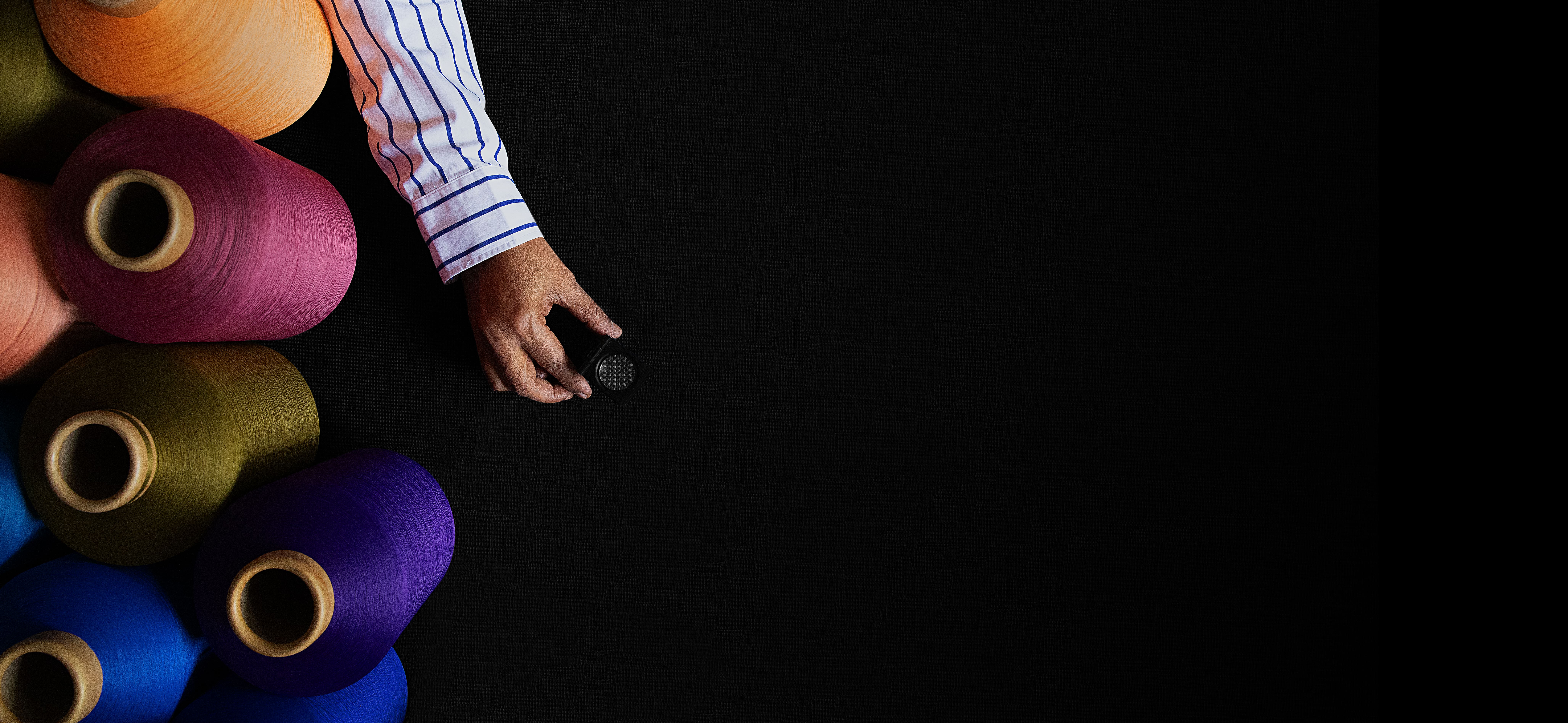 A vibrant display of yarn spools in Oaxaca, showcasing diverse colors and textures in a textile workshop.